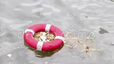 救生圈，如同河中漂浮的老垃圾.. 曾经有用的东西，如果不适当地消除，就会造成污染。